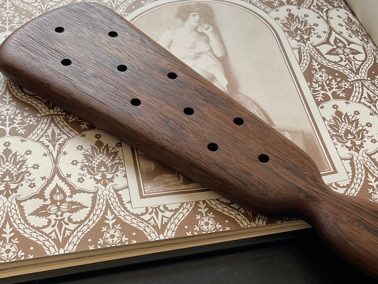 The back side of an Edwardian spanking paddle by LRS Toys shows off small blister holes