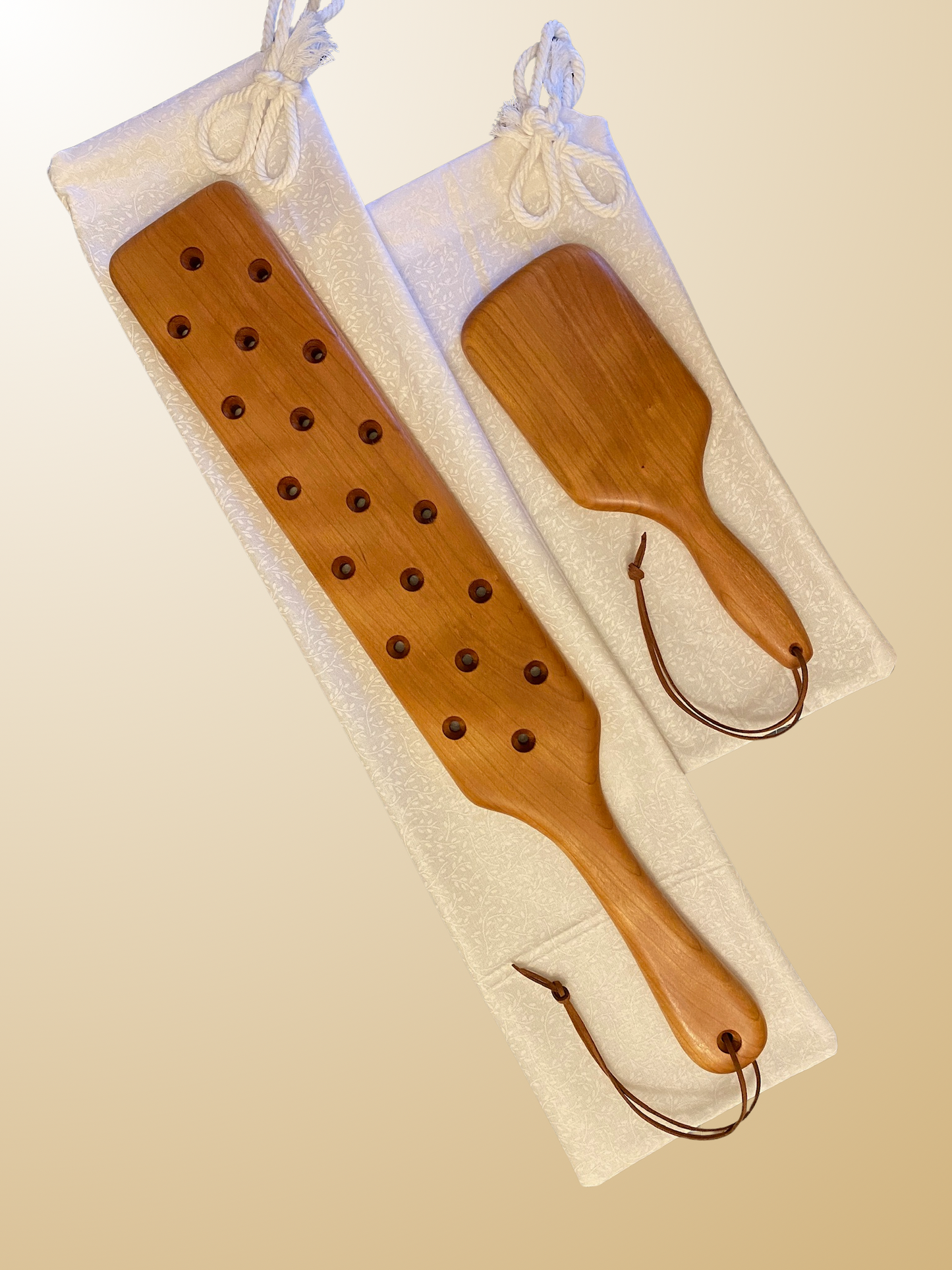 22" ATP Frat Paddle with Holes pictured in Mahogany beside an LRS Abby Hairbrush paddle, also in Mahogany. 